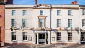A historic building with a symmetrical facade, large windows, and a central entrance flanked by columns. - The Angel Hotel Abergavenny (Abergavenny)