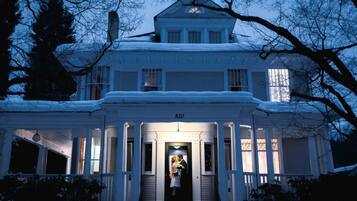 A large white house with a number 820 on the front, a porch, and a staircase leading to the entrance.