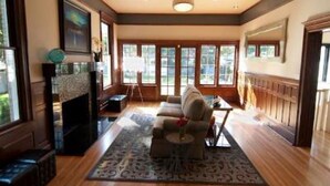 A spacious living room with a fireplace, large windows, and a comfortable seating area. - Blackwell Hotel (Coeur d'Alene)