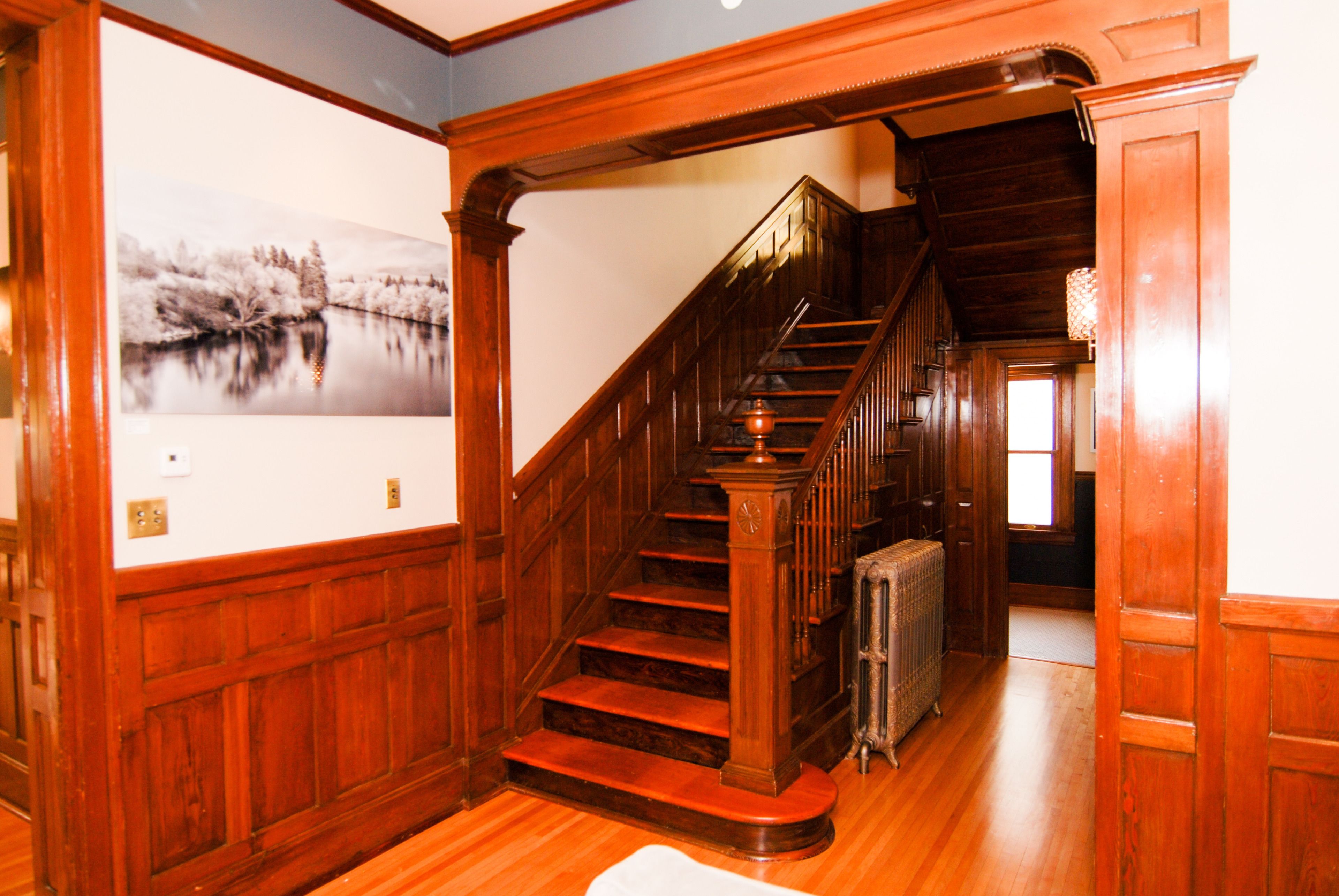 A wooden staircase with a radiator at the bottom.