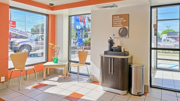 L’intérieur d’un motel, avec un comptoir d’accueil, des chaises, une poubelle et un panneau indiquant que les appels locaux sont gratuits.