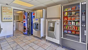Une cuisine professionnelle équipée de distributeurs automatiques, notamment un distributeur de Pepsi, de glaçons et un autre pour les collations.