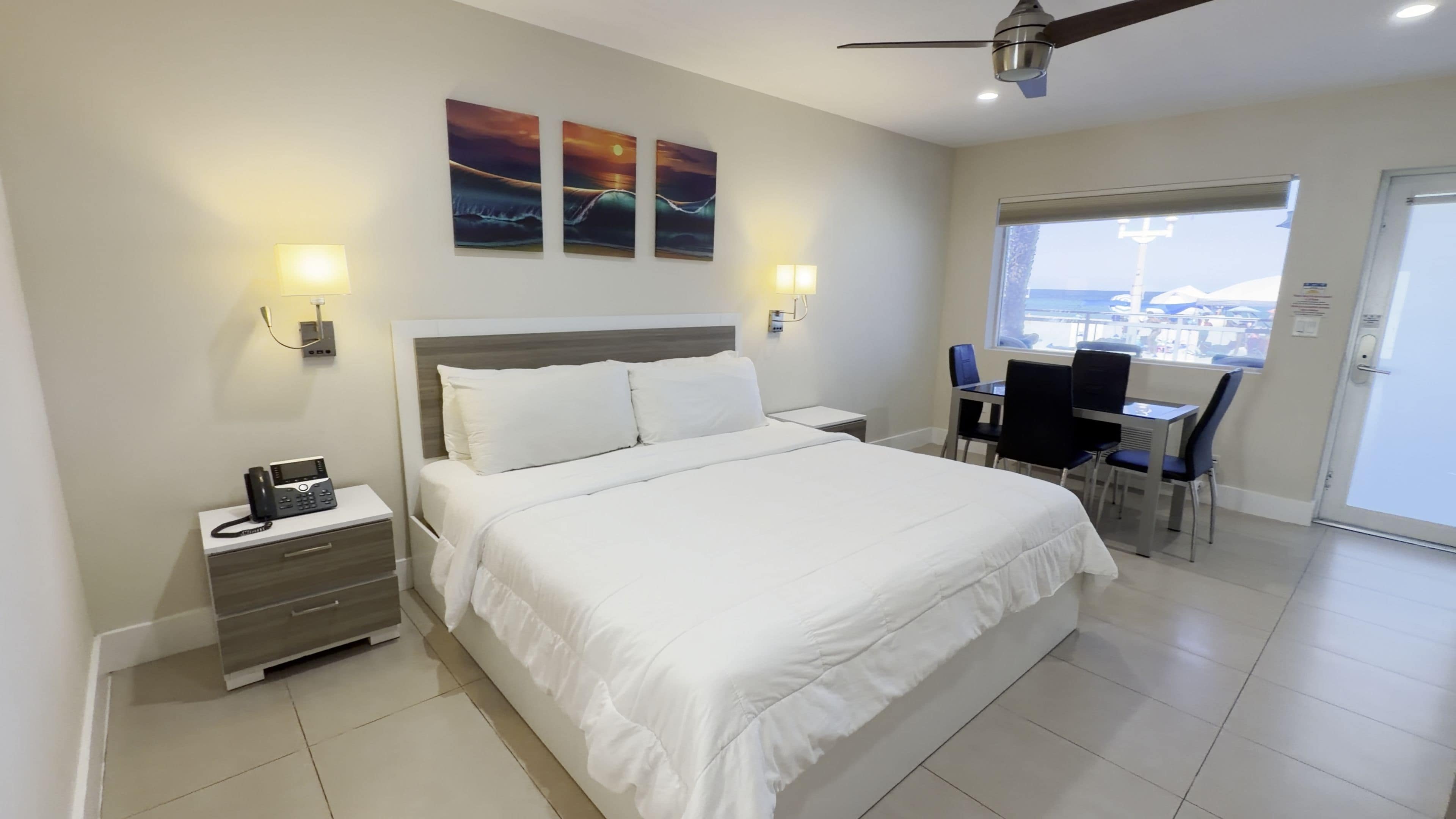 Ein Hotelzimmer mit Bett, Nachttischen, einem Schreibtisch und Stühlen.