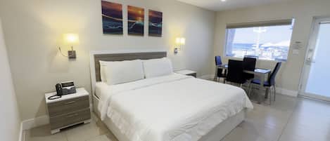Una habitación de hotel con cama, mesitas de noche, escritorio y sillas.