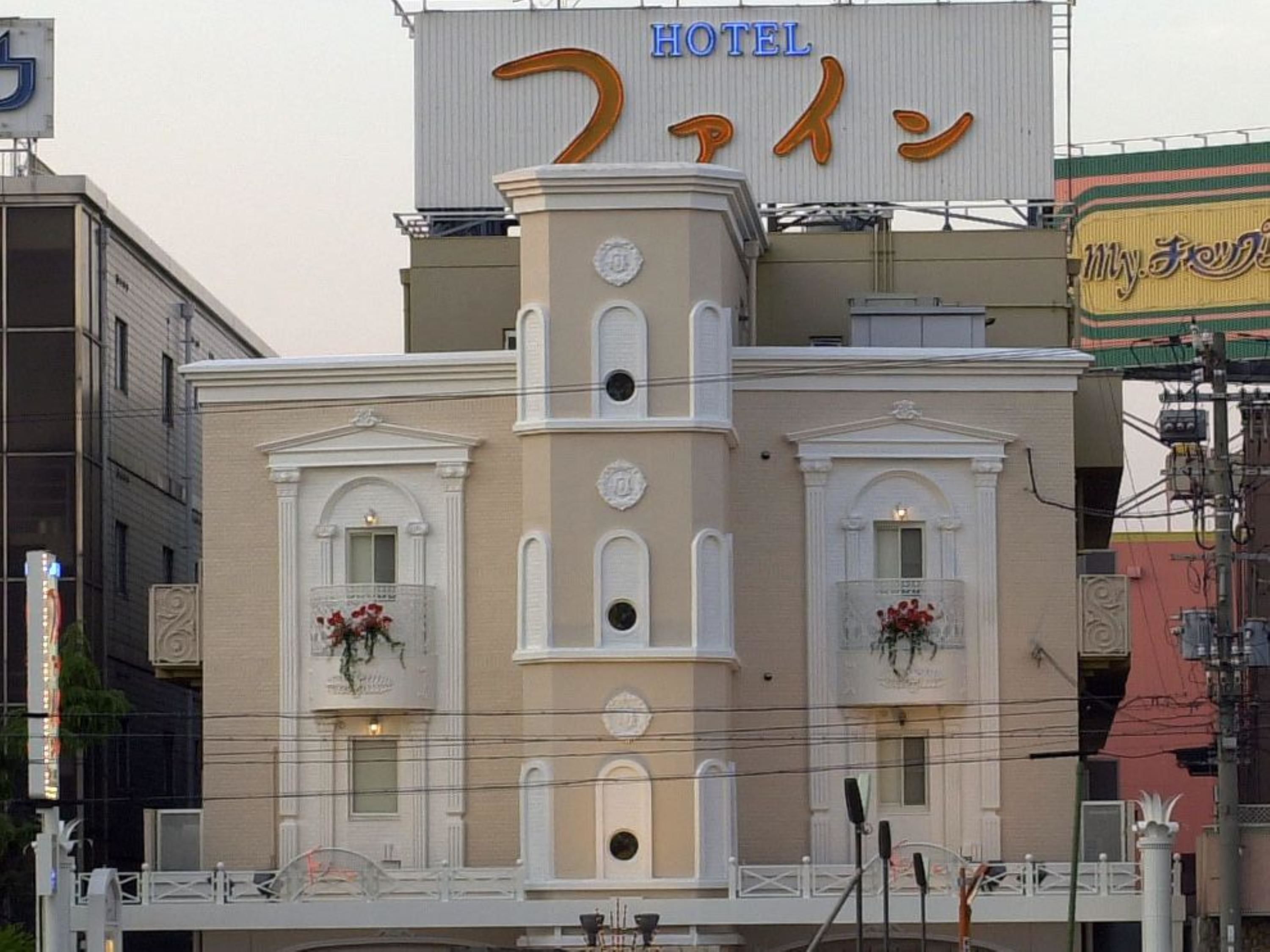 A hotel with a classic architectural style, featuring two symmetrical wings with arched windows and a central tower.