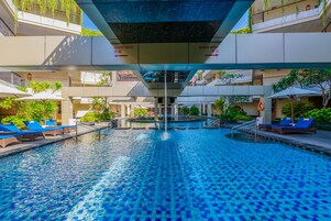 Una piscina al aire libre, sillones reclinables de piscina
