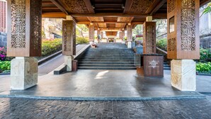A covered entrance with a stone staircase leading to a lobby area, featuring decorative pillars and a sign for 'Belldesk IT Consulting'.