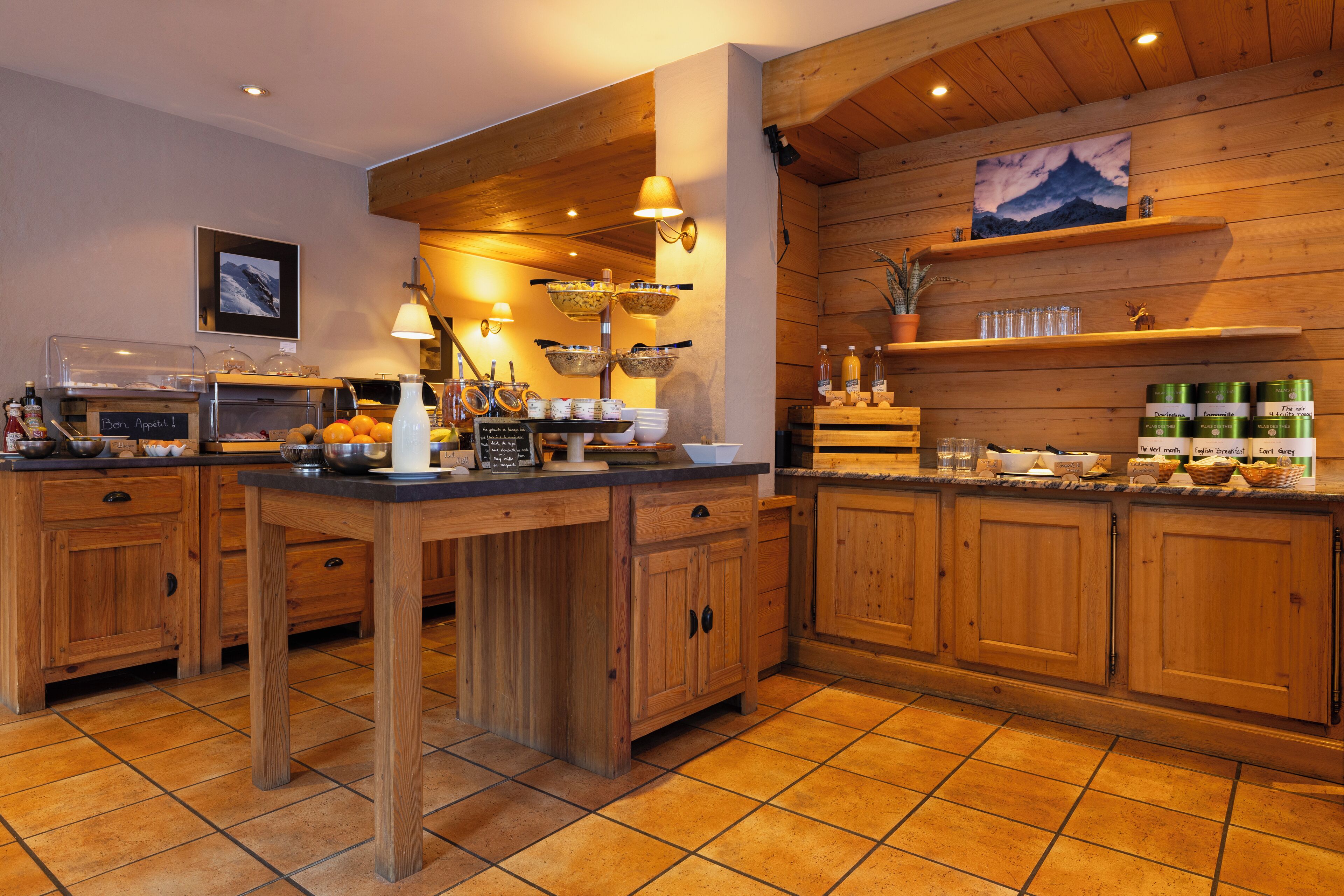 A kitchen with wooden cabinets, a central island, and a breakfast bar.