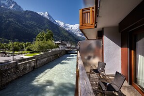A balcony with a view of a river and mountains. -   Hôtel de l'Arve by HappyCulture  (Chamonix-Mont-Blanc)