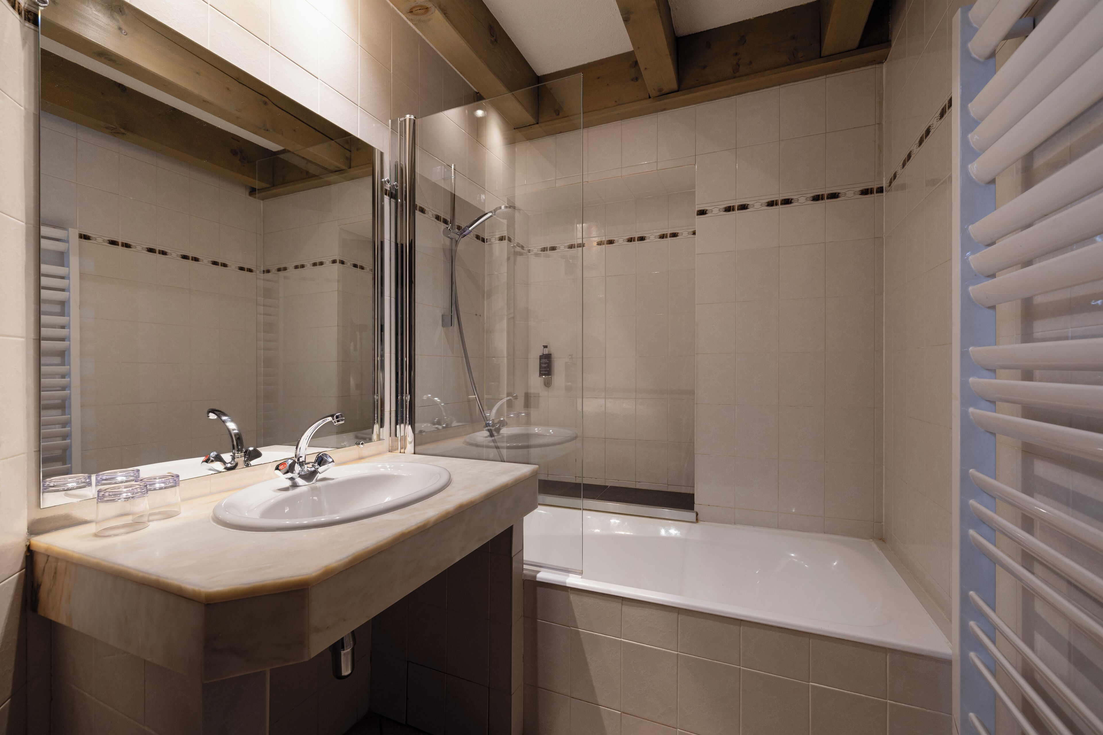 Een badkamer met twee wastafels, een douche en een bad.
