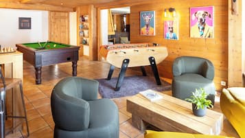 Una habitación acogedora con mesa de billar, mesa de fútbol de mesa y asientos cómodos.