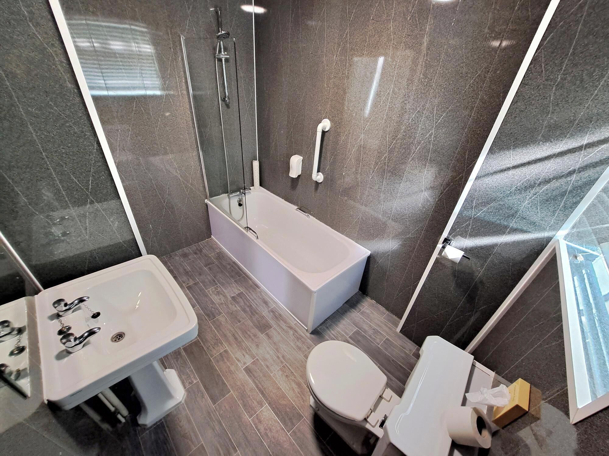 A modern bathroom with a bathtub, toilet, and sink.