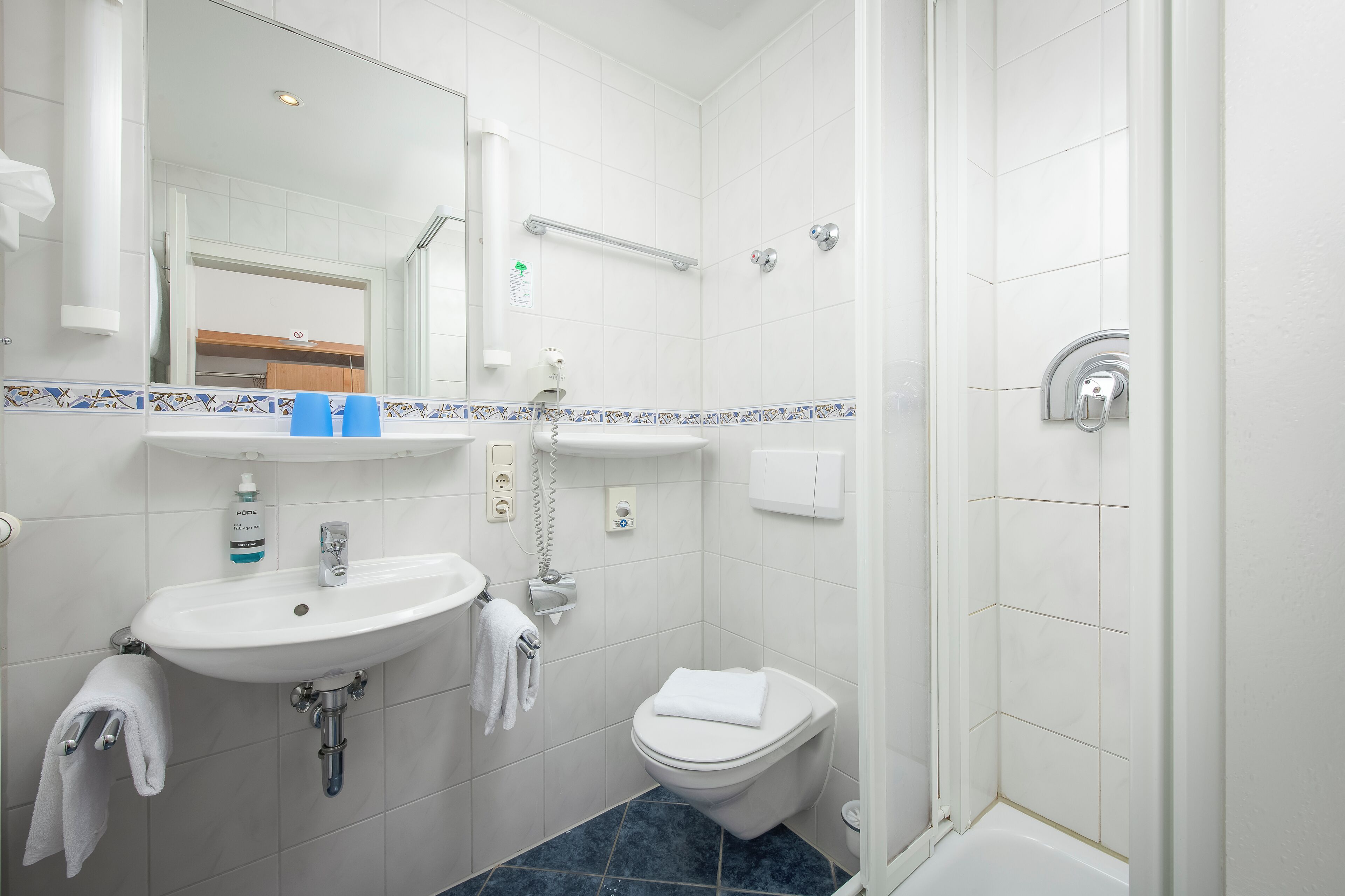 Un baño con lavamanos, inodoro y ducha.