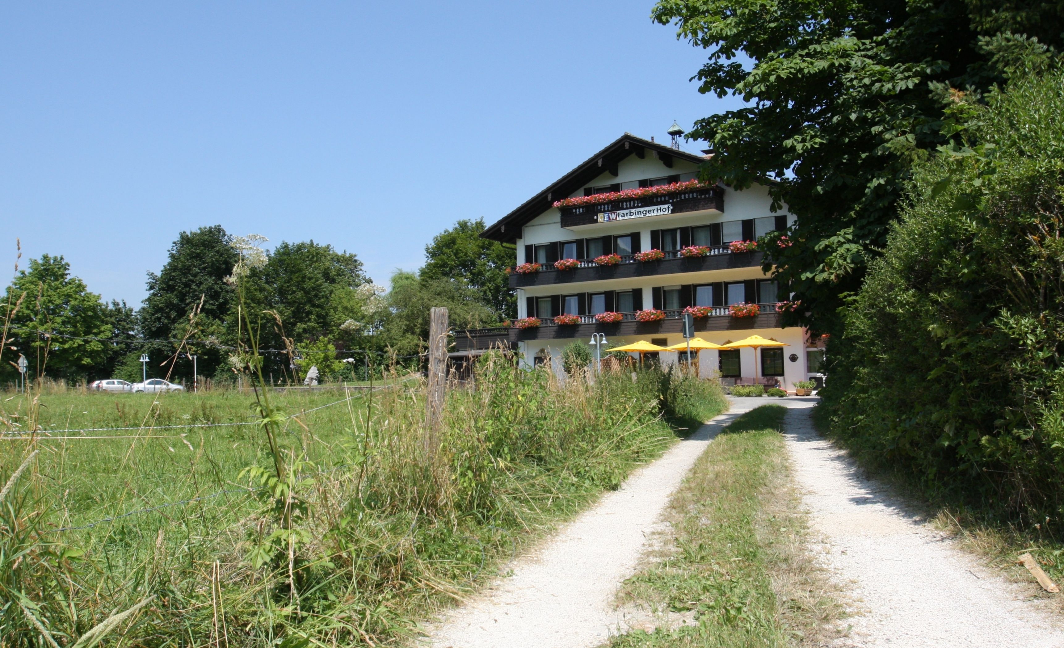 A hotel with a double-story structure, balconies with flower boxes, and a gravel path leading to the entrance.
