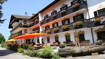 Stunning building with balconies, windows, and outdoor seating areas amidst a beautifully maintained garden.
