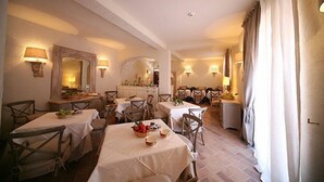 A dining area with multiple tables and chairs, warm lighting, and a cozy atmosphere. - Il Poggio Luxury Country Resort (Graniti)