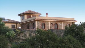 A two-story house with a stone facade, arched windows, and a tiled roof. - Il Poggio Luxury Country Resort (Graniti)