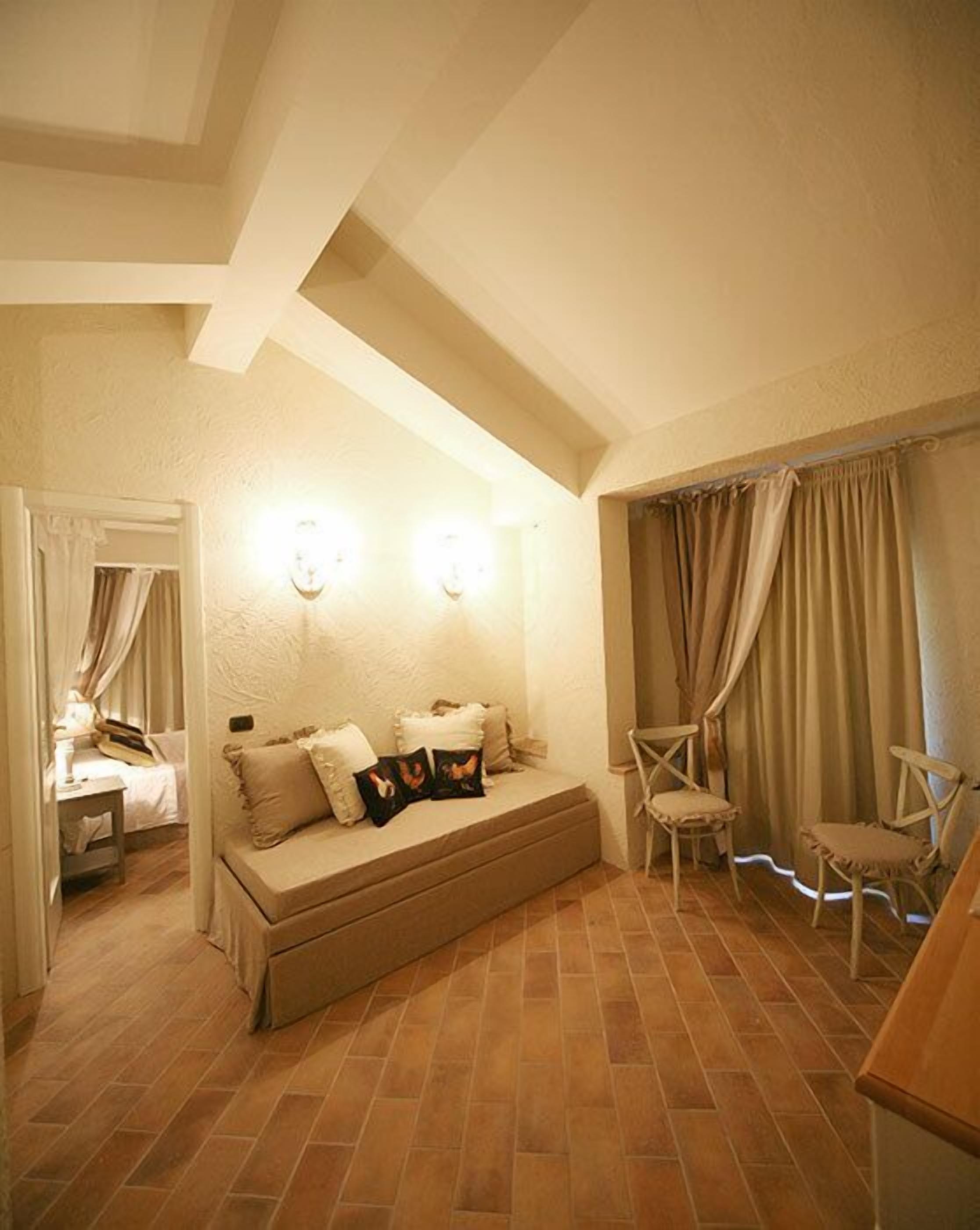 Un dormitorio acogedor con sofá cama, mesita de noche y una silla.