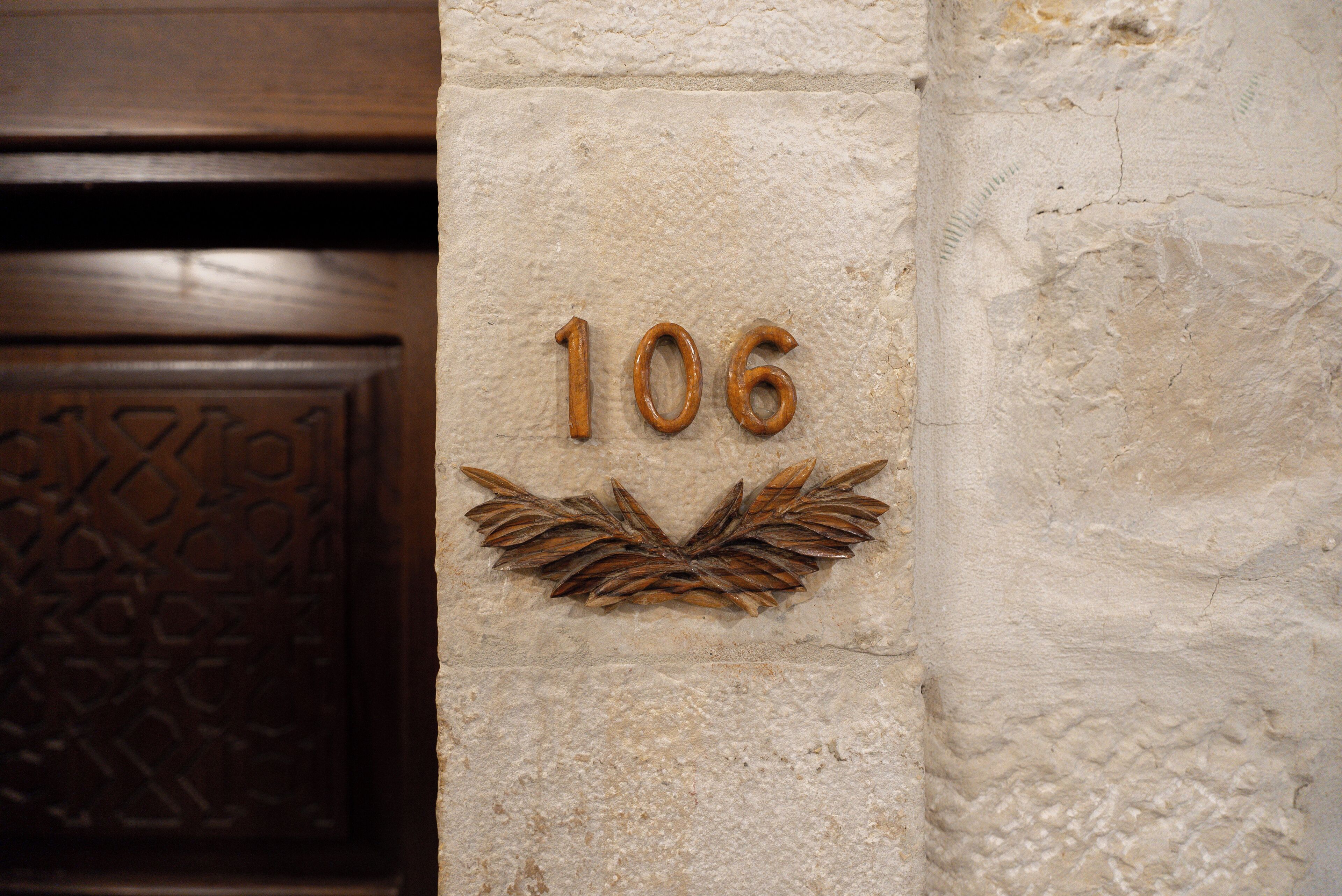 A wall with the number '106' and a decorative leaf pattern.
