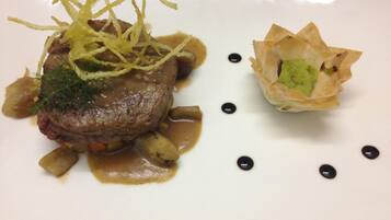 Un plato con filete, verduras y salsa.