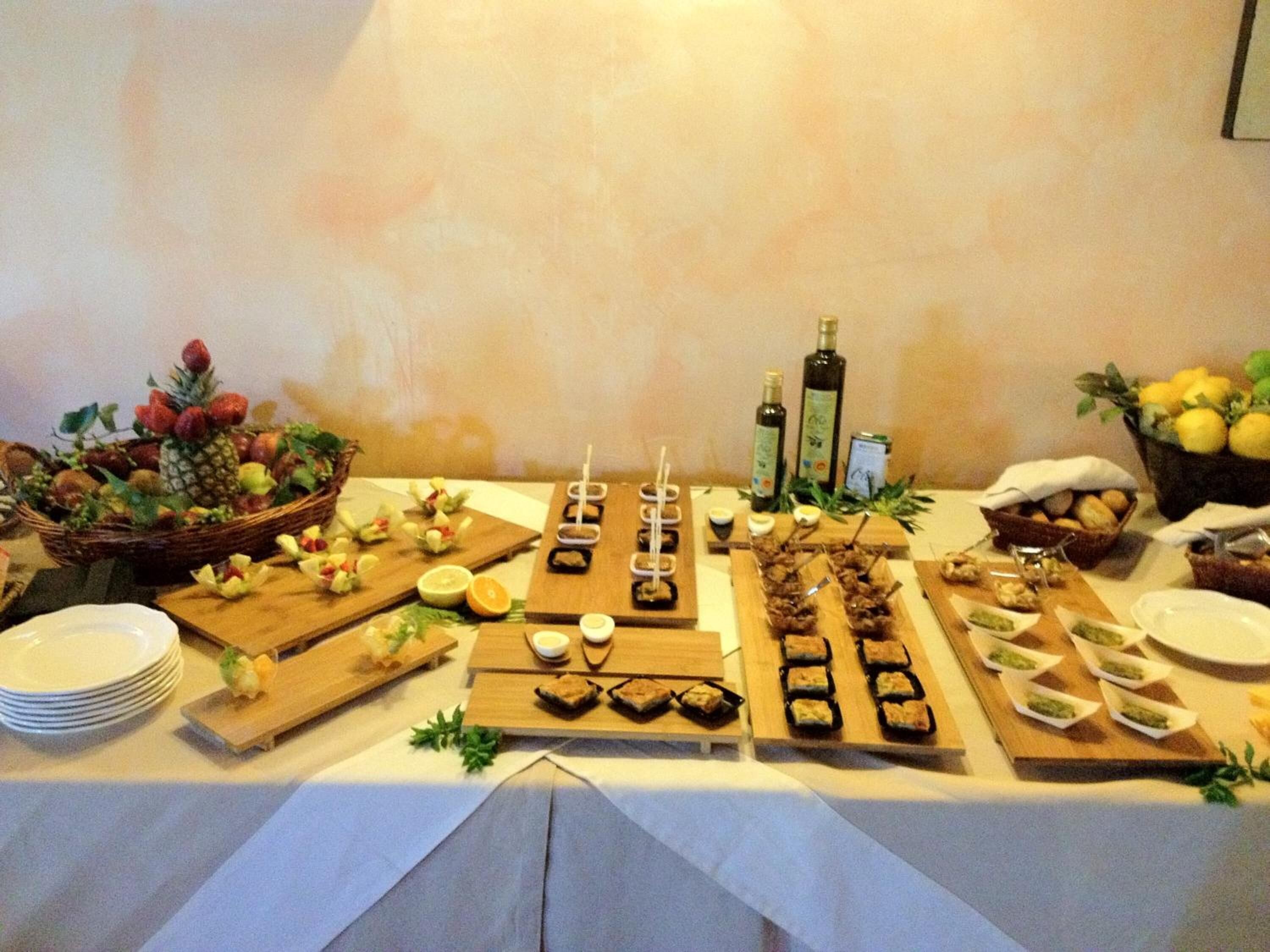 A buffet table with various food items, including fruits, cheeses, and meats, arranged on wooden boards.