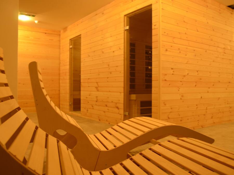 A wooden interior with a bench and a door.