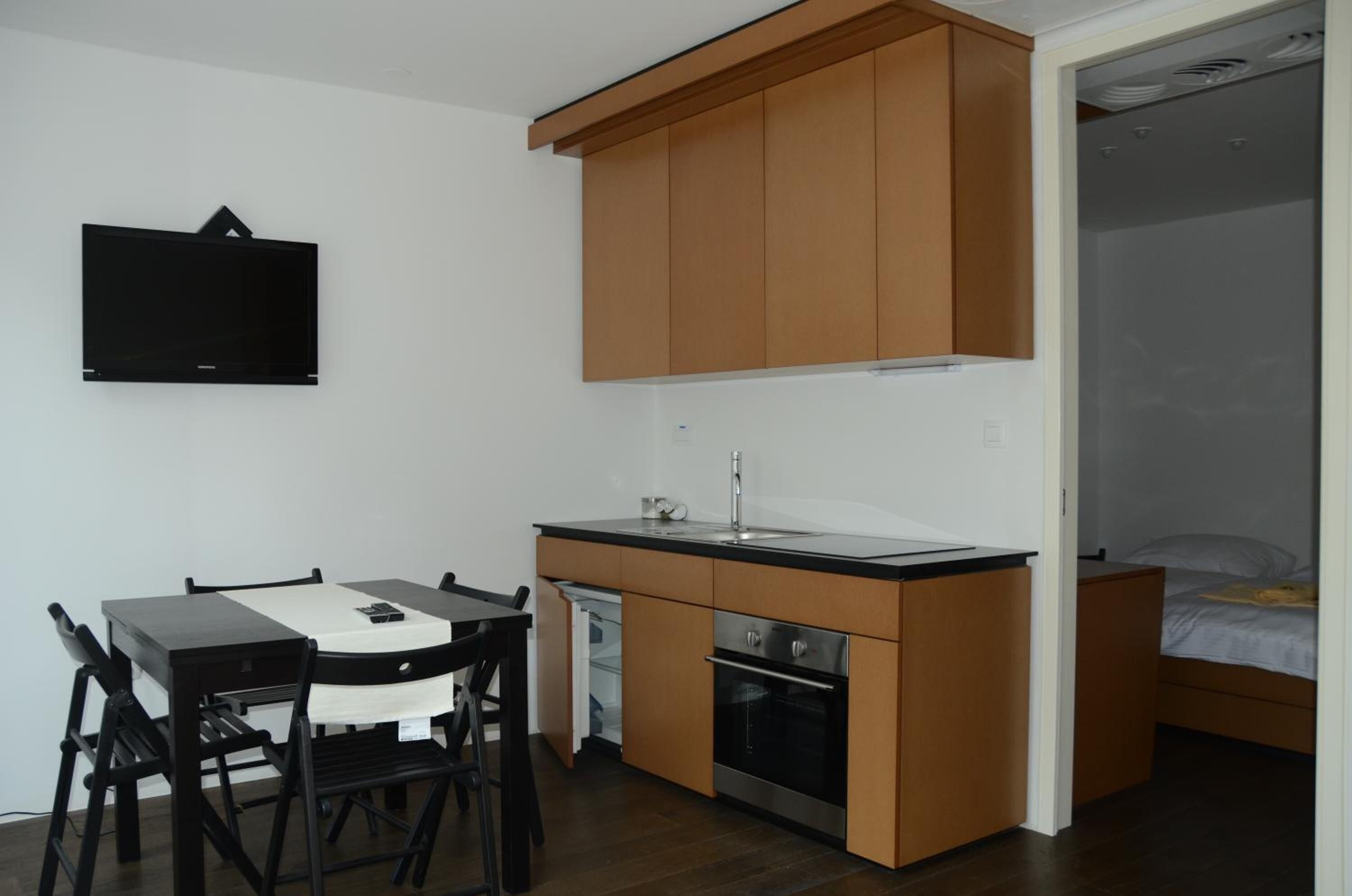 A compact kitchen with a dining area, a built-in oven, and a small sink.