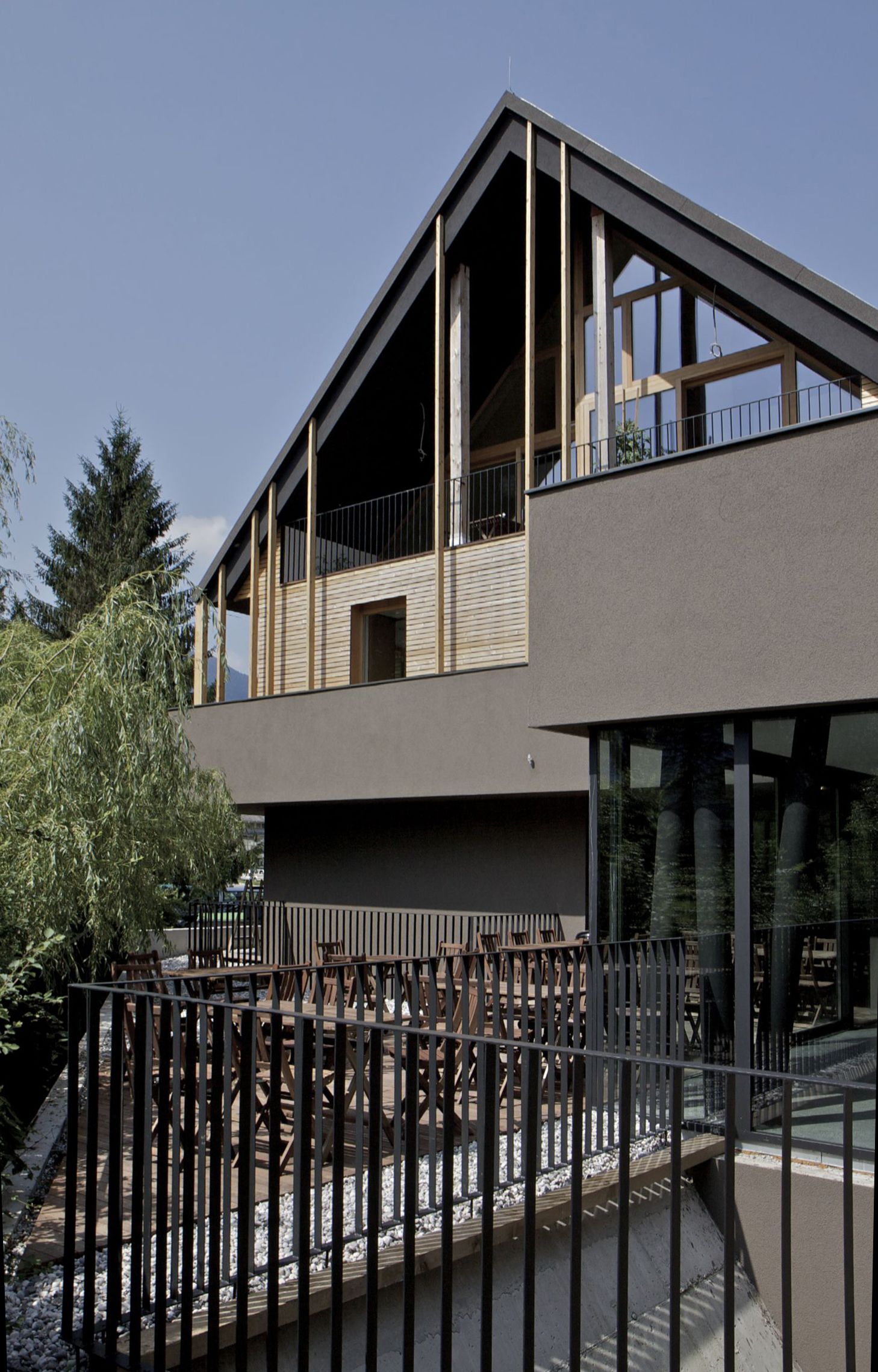 Un immeuble moderne à deux étages, doté de grandes fenêtres et d’un balcon.
