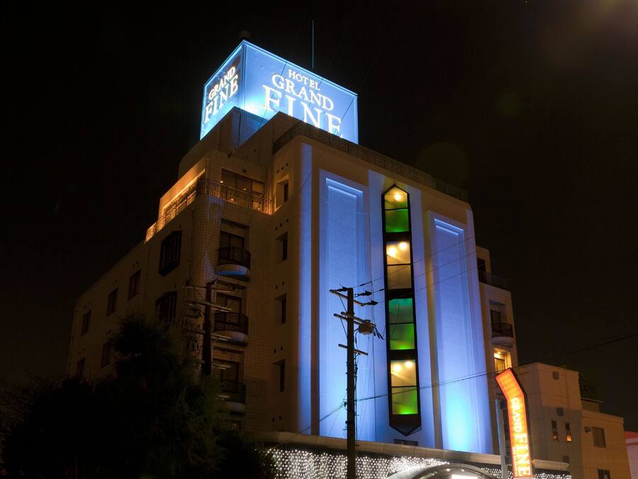 A hotel with a prominent 'Grand Fine' sign, large windows, and a modern facade.
