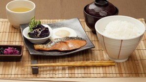 A traditional Japanese meal with rice, salmon, egg, and pickled vegetables on a bamboo mat. - Fine Garden Umeda (Osaka)