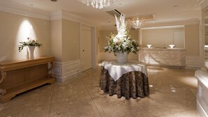 A spacious lobby with a marble floor, a wooden bench, a table with a lace tablecloth, and a large chandelier. - Hotel Fine Aroma Dotonbori (Osaka)
