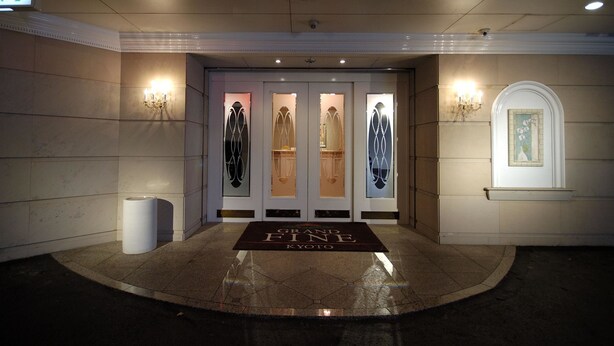 Ingresso di un hotel con un'ampia hall, una reception e un quadro appeso al muro.