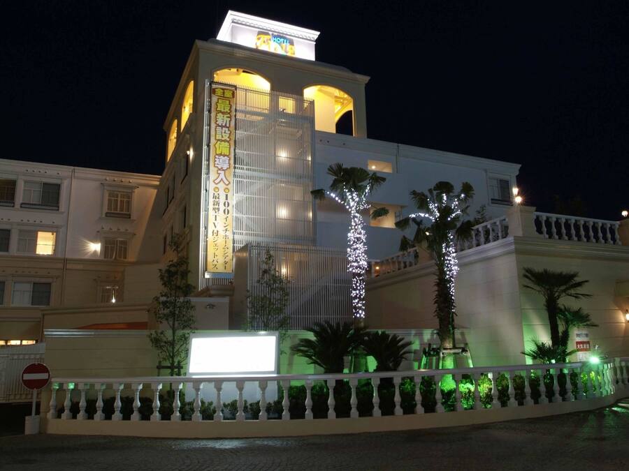 Un hotel con una torre imponente, una segnaletica che indica una nuova costruzione e un ingresso con cancello.