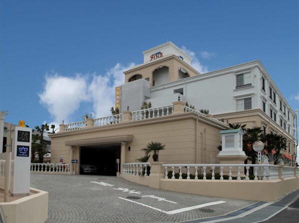 A hotel with a prominent entrance, a covered driveway, and a clear blue sky. - Hotel Fine Garden Toyonaka Itami Airport (Toyonaka)
