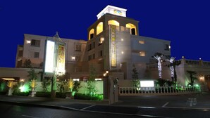 A hotel with a modern facade, illuminated signage, and a gated entrance. - Hotel Fine Garden Toyonaka Itami Airport (Toyonaka)