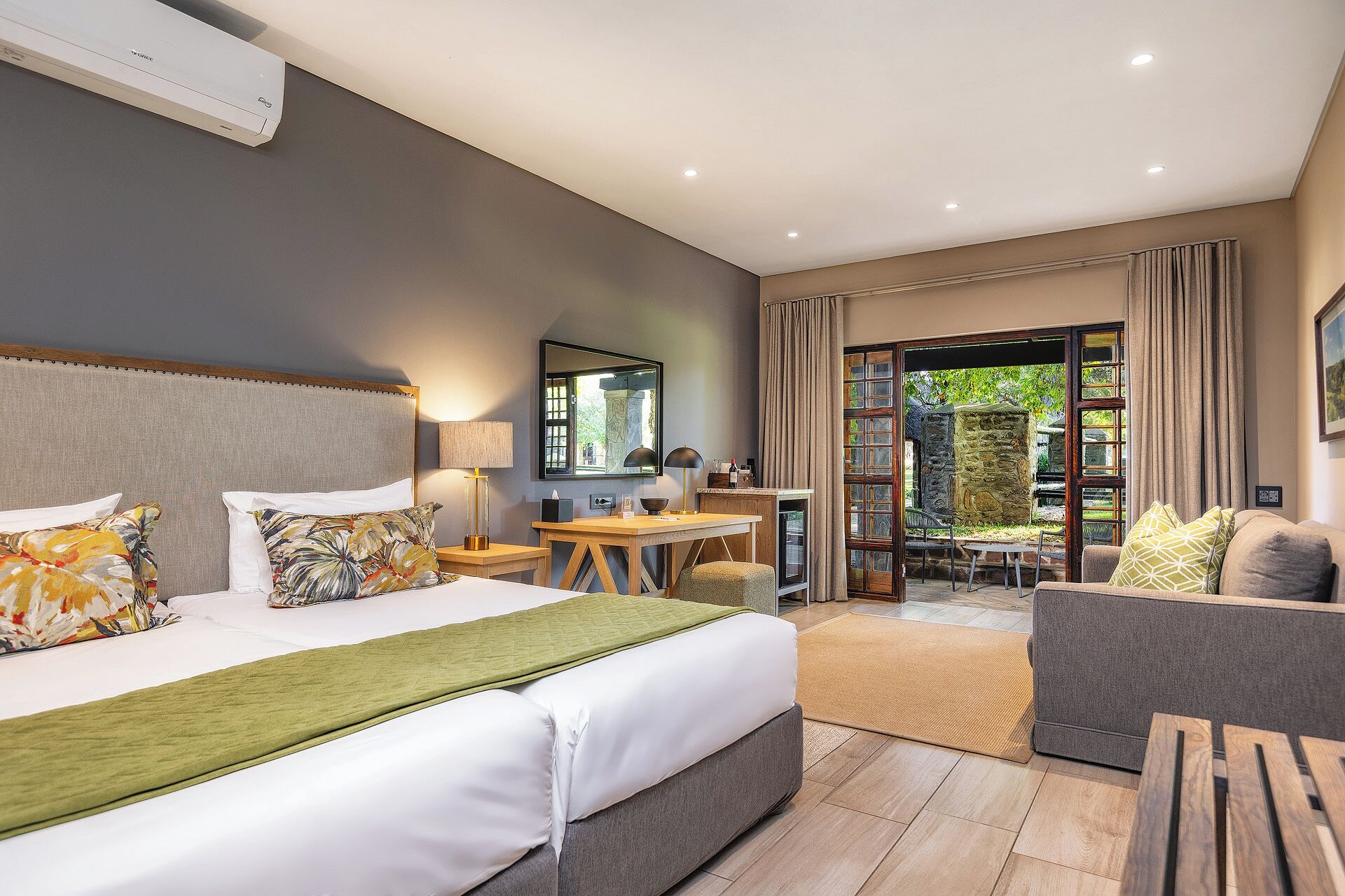 Une chambre d’hôtel équipée d’un lit, d’un bureau, d’une chaise, d’un canapé et offrant une vue sur l’extérieur.