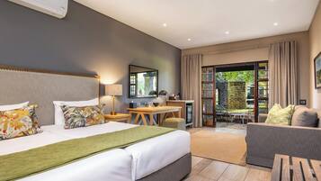 Une chambre d’hôtel équipée d’un lit, d’un bureau, d’une chaise, d’un canapé et offrant une vue sur l’extérieur.