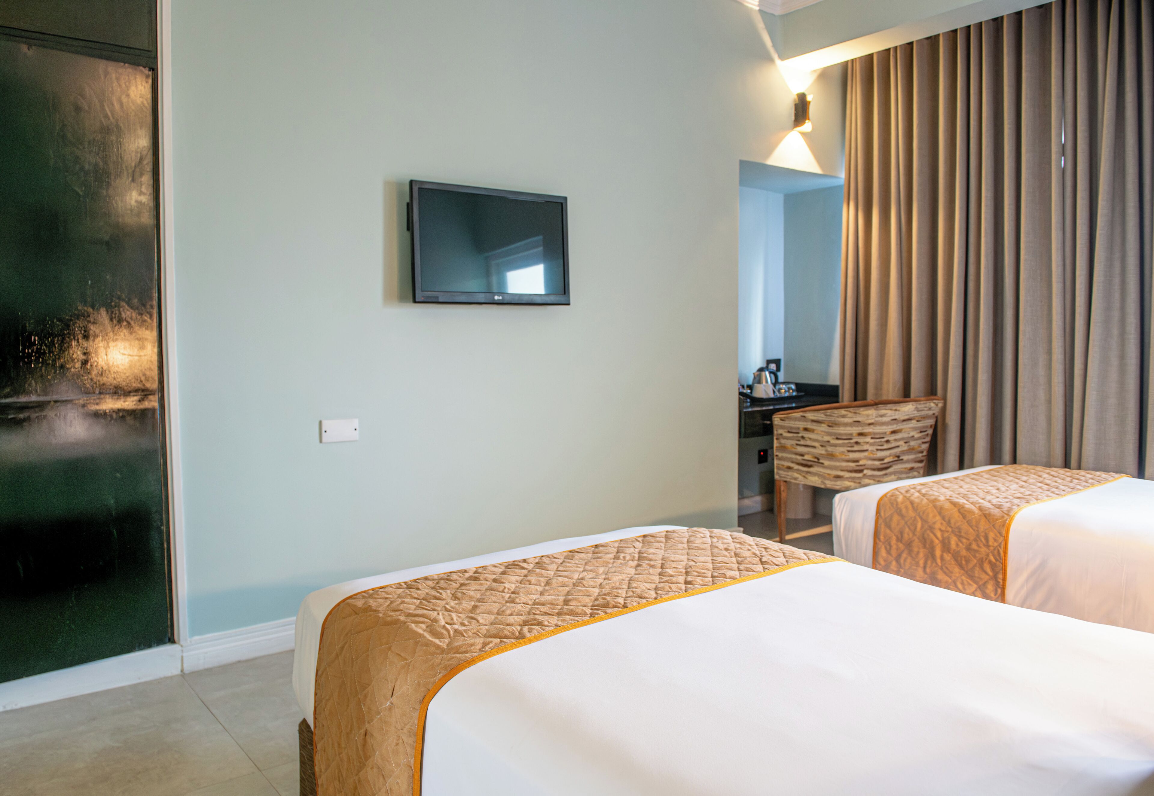Une chambre d’hôtel avec deux lits, une télévision, un bureau et une chaise.