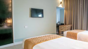 Une chambre d’hôtel avec deux lits, une télévision, un bureau et une chaise.