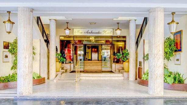 A hotel entrance with a marble floor, a staircase, and potted plants. - New Ambassador Hotel (Harare)