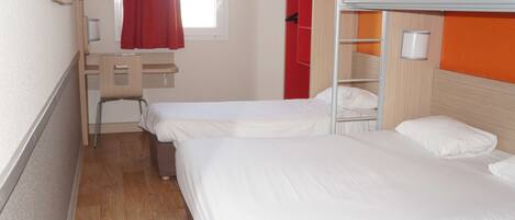 A room with two beds, a desk, and a red wardrobe.