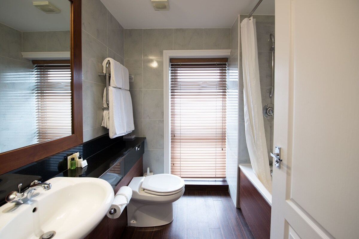 A bathroom with a sink, toilet, and shower.