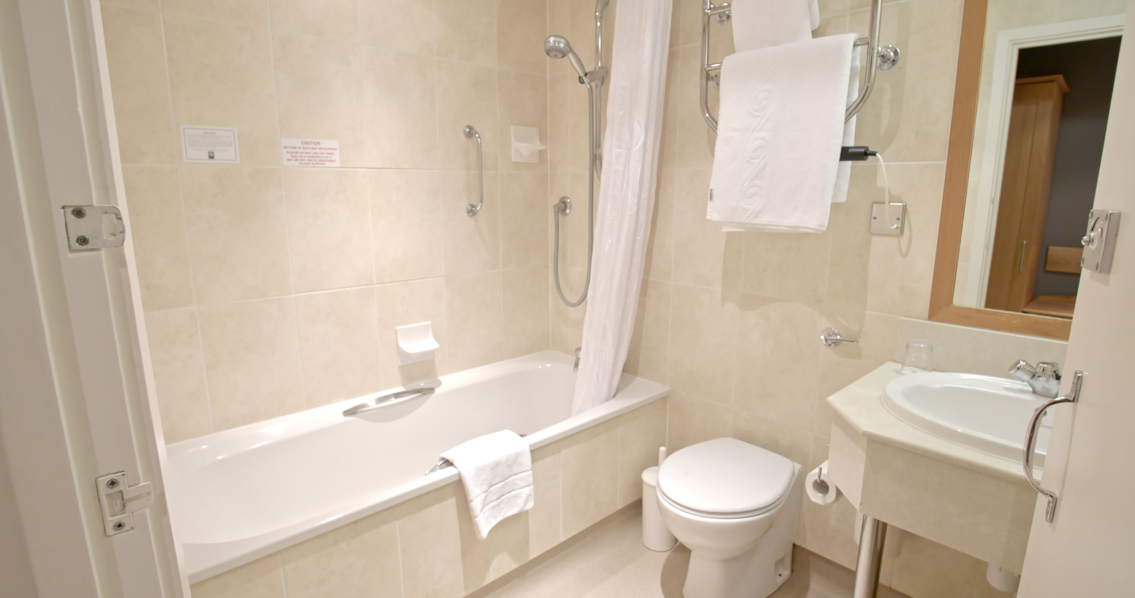 A bathroom with a bathtub, toilet, and sink.