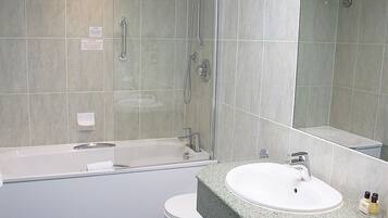 A modern bathroom with a bathtub, toilet, and sink.