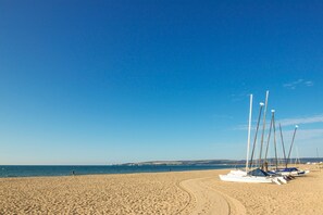 A sandy beach with several sailboats lined up on the shore. - Sandbanks Hotel (Poole)