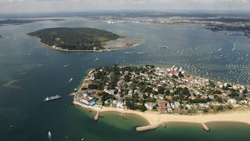 Eine Luftaufnahme einer Küstenstadt mit Strand, Hafen und Wohngebieten.