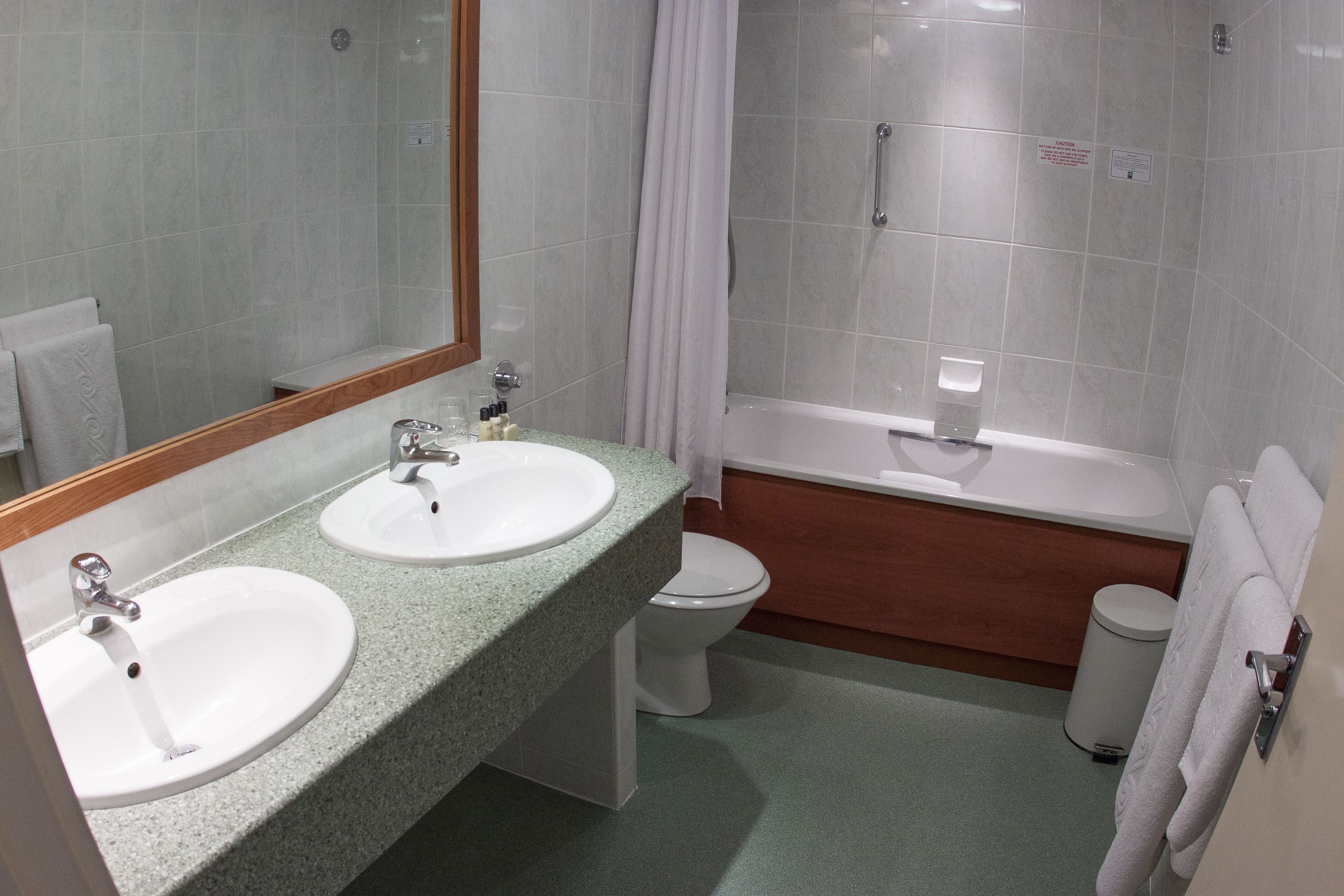 A bathroom with two sinks, a toilet, a bathtub, and a shower.