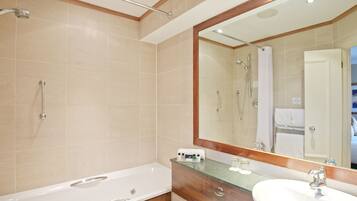 A modern bathroom with a bathtub, a sink, and a large mirror.