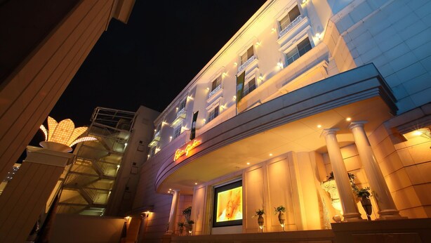 A hotel entrance with a grand facade, illuminated windows, and a large digital display. - Hotel Fine Garden Kyoto Minami (Kyoto)