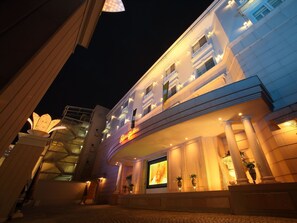A hotel entrance with a grand facade, illuminated windows, and a large digital display. - Hotel Fine Garden Kyoto Minami (Kyoto)